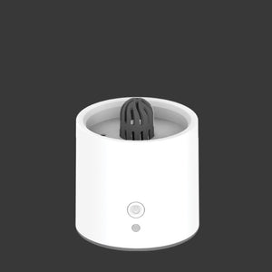 White cylindrical device with a black top on a dark background