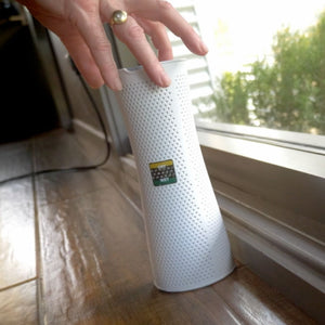 White Dry Styx tower on a windowsill with a hand reaching towards it