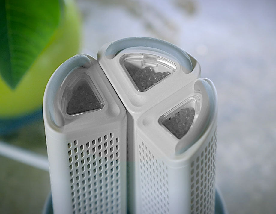 Close-up of a white air purifier with gray filters on a blurred background
