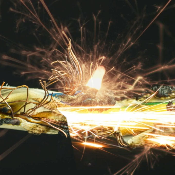 Close-up of a welding torch with sparks in action on a dark background
